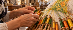 Manos trabajando encaje de bolillos en color durante un taller en Bruselas