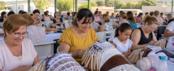 Familias y artesanas compartiendo encaje de bolillos en un encuentro extremeño