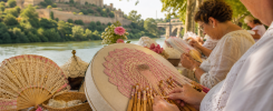 Encajeras trabajando con bolillos junto al río Guadaíra y el castillo de Alcalá